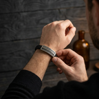 hombre modelando pulsera de cuero con placa metalica estilo griego
