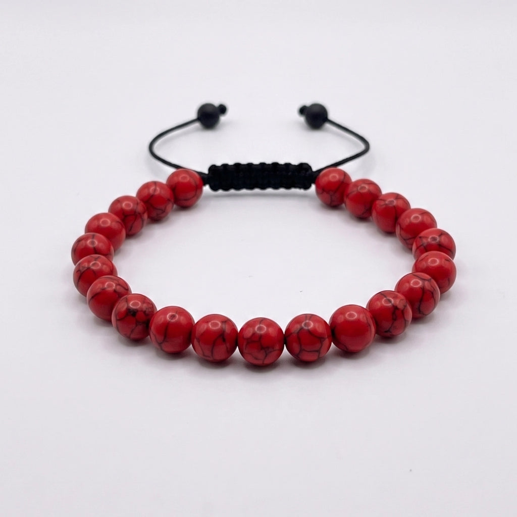 Pulsera de turquesa roja con nudo corredizo y espaciador metálico grabado con el logotipo KRV