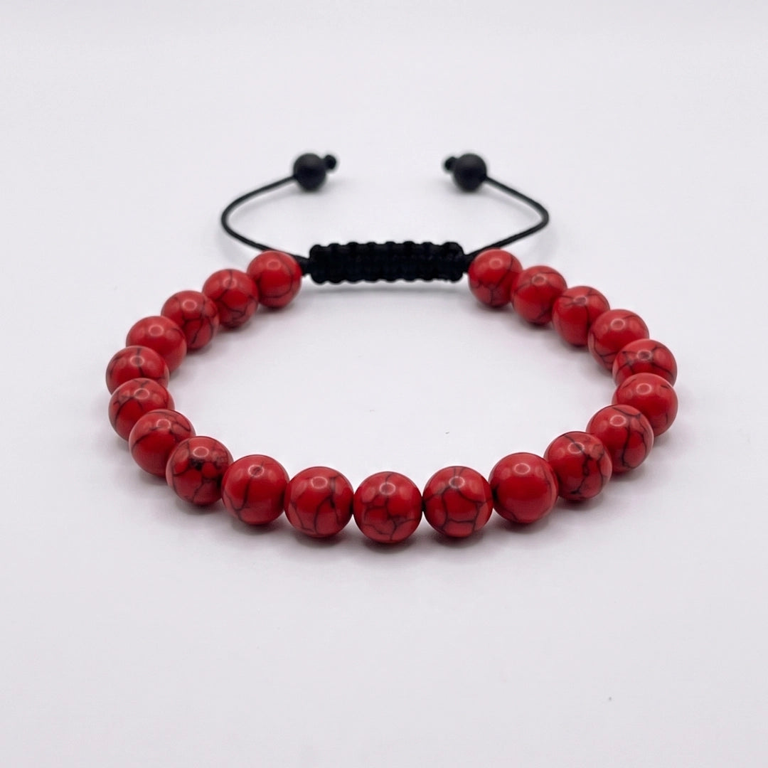 Pulsera de turquesa roja con nudo corredizo y espaciador metálico grabado con el logotipo KRV