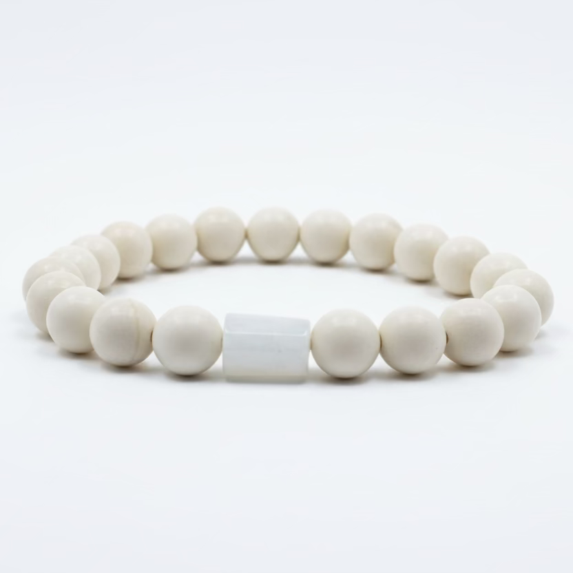 Pulsera blanca brillante de material cerámico con una piedra luna (moonstone) incrustada en el centro.
