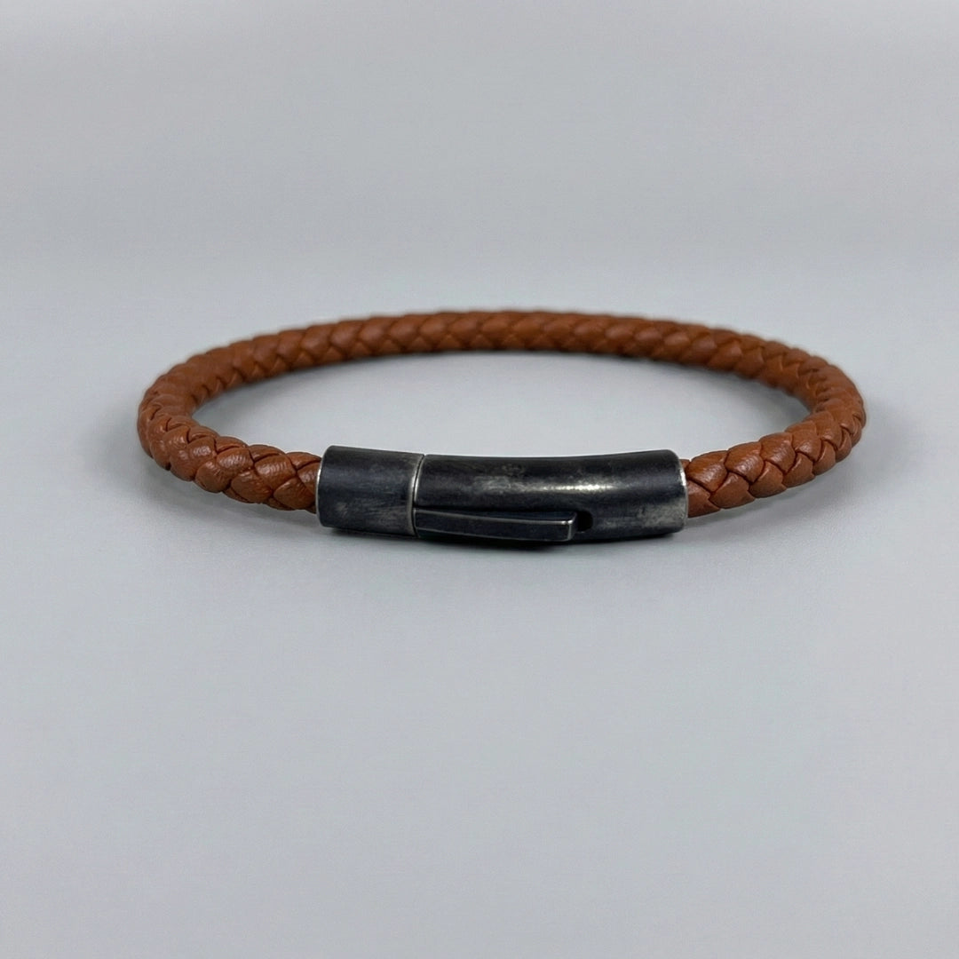 Vista posterior de pulsera de cuero trenzado bovino color marrón cálido con broche de color negro envejecido