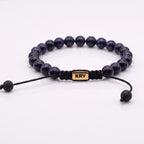 Primer plano del separador exclusivo KRV en pulsera sobria de cuentas de lluvia dorada azul.