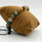 Pulsera de hombre con cuentas esféricas de Ágata India natural mostrando variedad de colores verde, rojo y tonos tierra