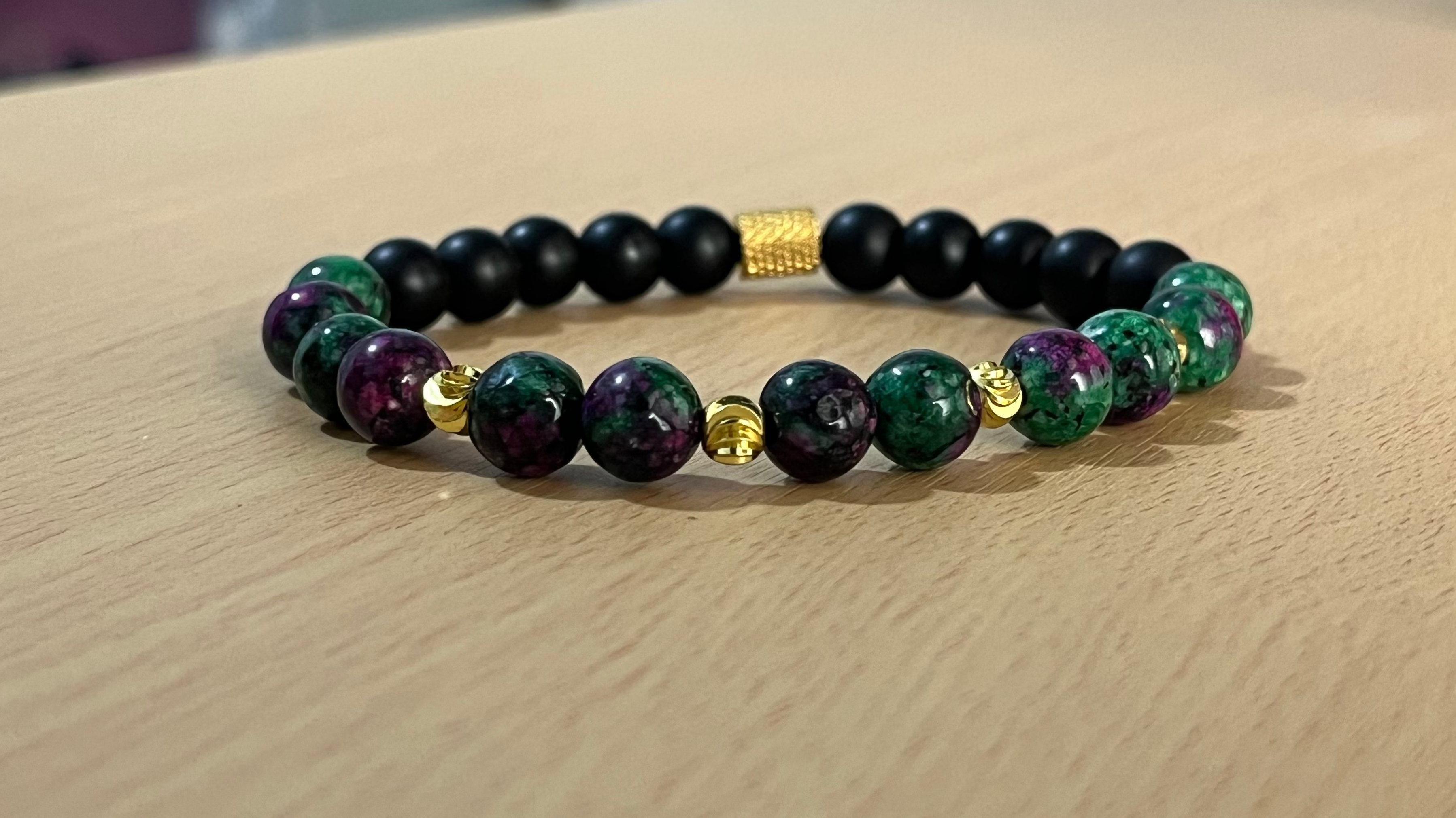 Pulsera sobre mesa de madera para hombre hecha con Rubí Anyolita con piedras natural de onix mate 