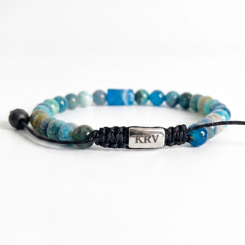 Fotografía sobre fondo oscuro de pulsera minimalista para hombre destacando tonos azules profundos y centro geométrico de apatita.