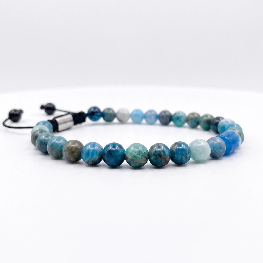 Detalle frontal de pulsera de apatita azul natural con diseño brutalista y ajuste de cordón negro para hombre.