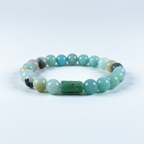 Pulsera elástica de cuentas de piedra amazonita natural de color verde agua sobre fondo blanco.