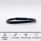Pulsera en fondo blanco profeisonal minimalista de un cordón de cuero redondo y broche de acero inoxidable