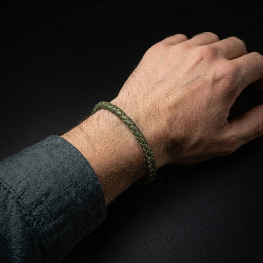 Pulsera de cuero trenzado color verde modelado por hombre en un fondo oscuro