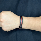 Persona usando pulsera de cuero redondo color rojo carmesí