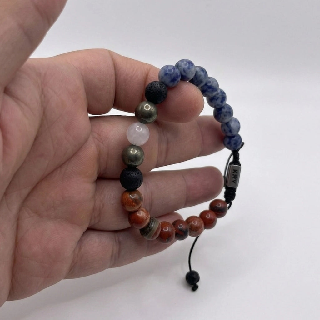 Detalle de cuentas de jaspe azul, jaspe rojo y pirita combinadas en pulsera artesanal masculina KRV.CO