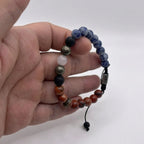 Detalle de cuentas de jaspe azul, jaspe rojo y pirita combinadas en pulsera artesanal masculina KRV.CO