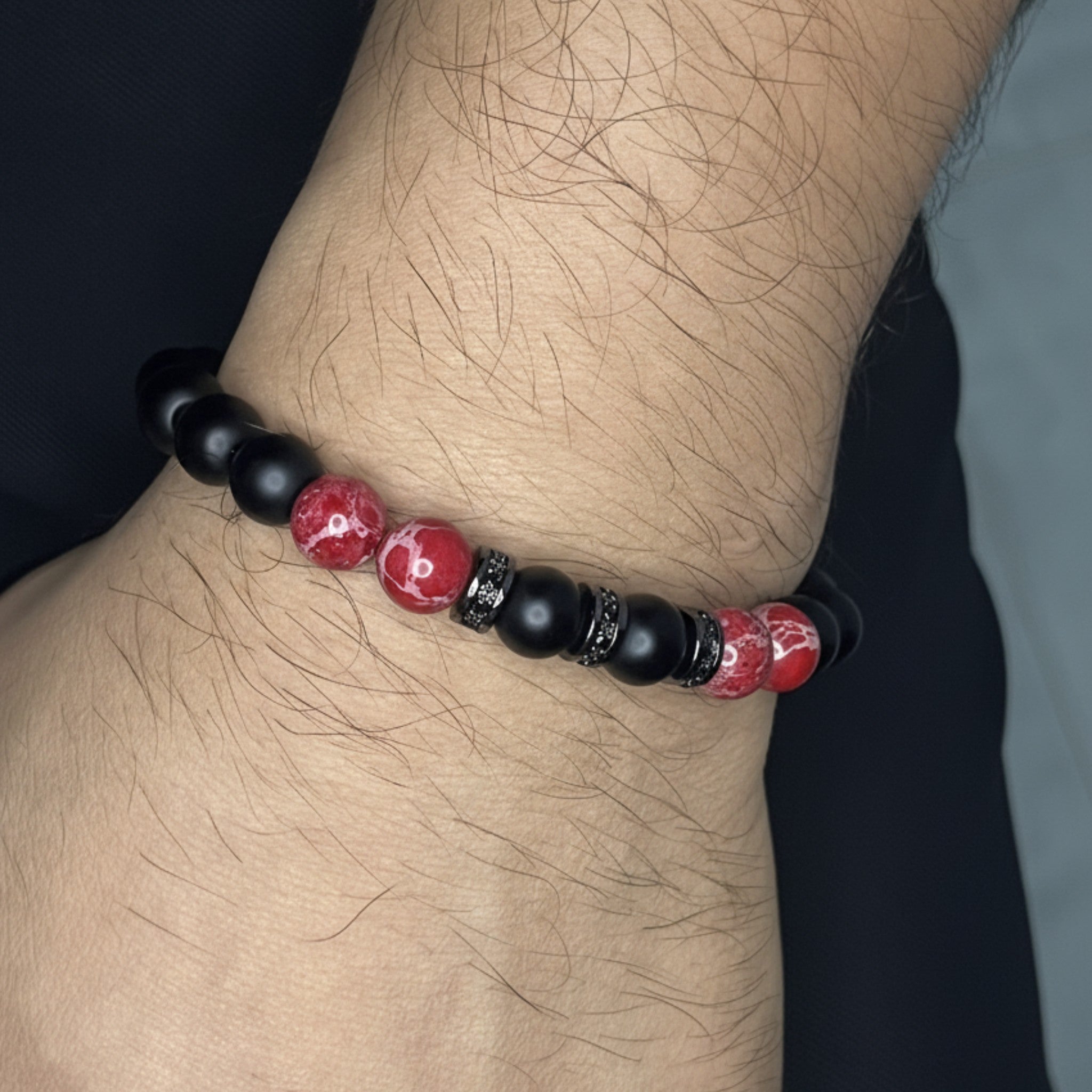 Pulsera ajustable Fuego Carmesí está diseñada con cuentas Onix-Mate y piedras Jaspe Rojo separadas entre sí por incrustaciones de circonita. 