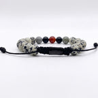 Vista posterior de pulsera de piedra natural donde se muestra el logo de la marca y atadas con nudo corredizo 