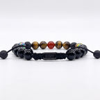 Pulsera con logo de marca KRV con nudo corredizo de piedras naturales ojo de tigre, ónix y cornalina natural en fondo blanco fotográfico
