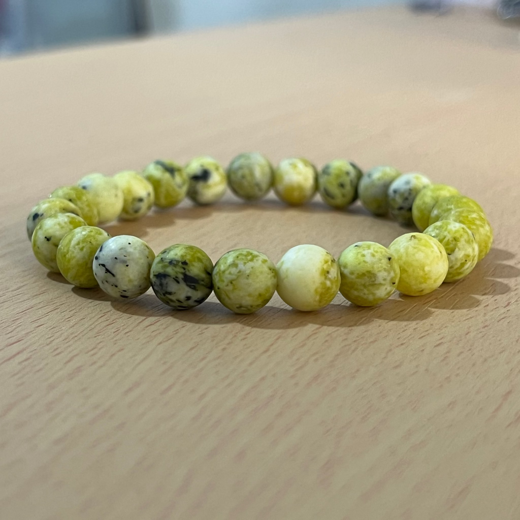 Pulsera o manilla serpentina sobre mesa de madera, accesorio para hombre, krv colombia