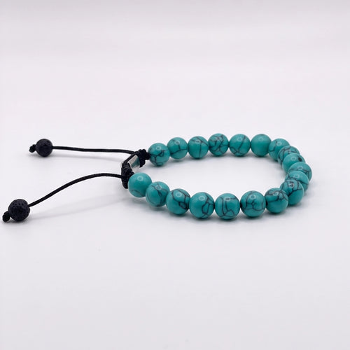 Pulsera masculina elaborada en turquesa verde sintética con vetas oscuras y sistema de nudo corredizo negro