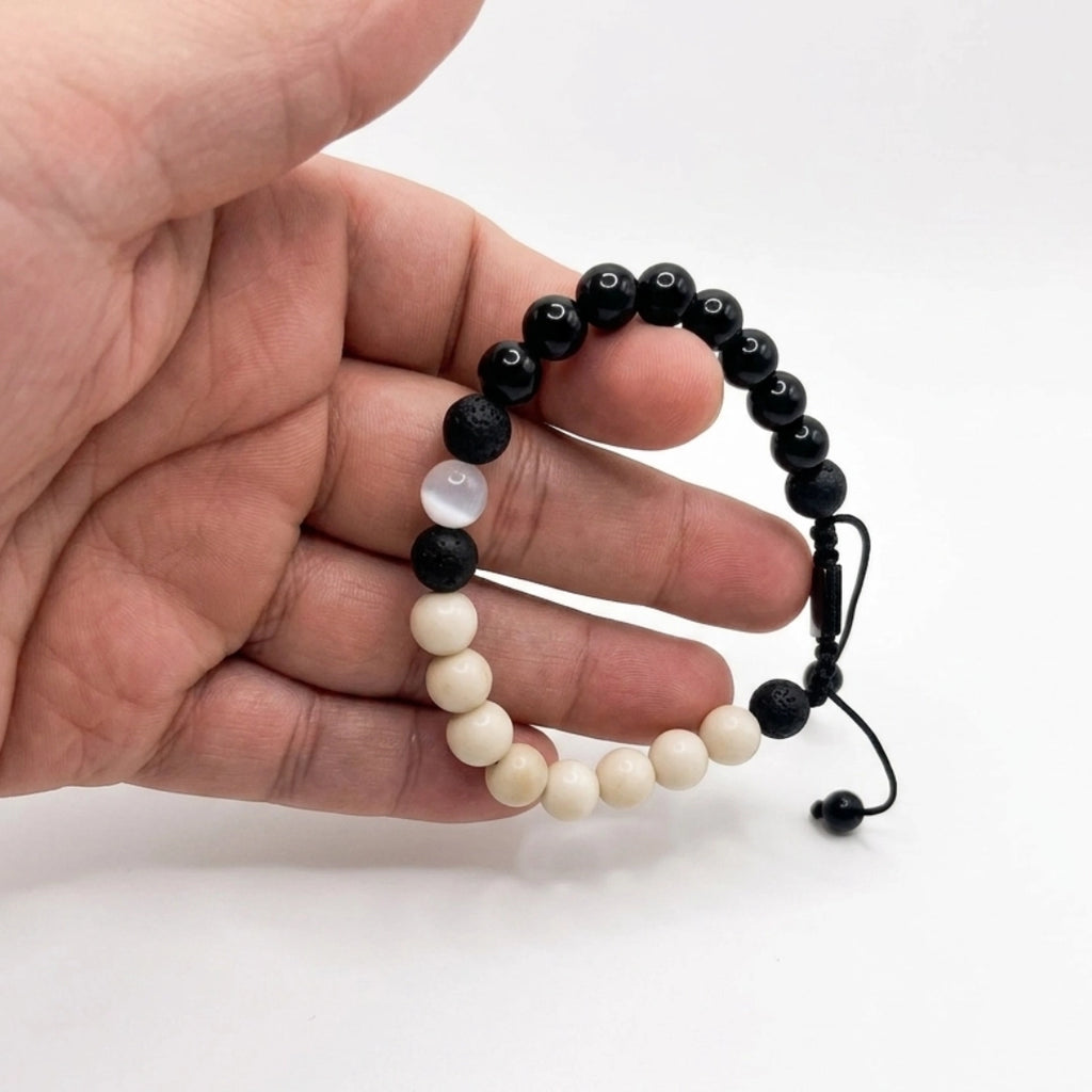 Pulsera hecha a mano con ónix negro sujetada en mano de una persona