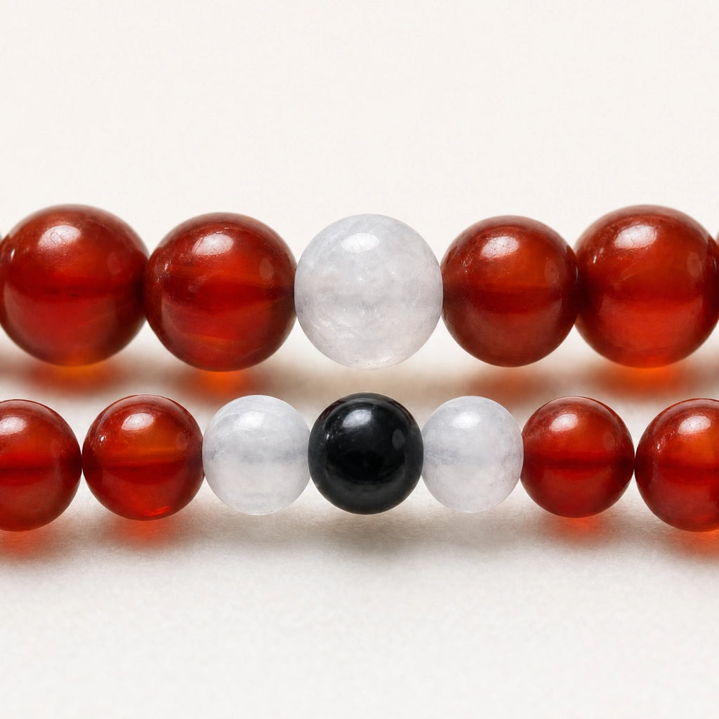 Detalle macro de pulseras de pareja en cornalina, jade blanco y turmalina negra