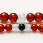 Detalle macro de pulseras de pareja en cornalina, jade blanco y turmalina negra