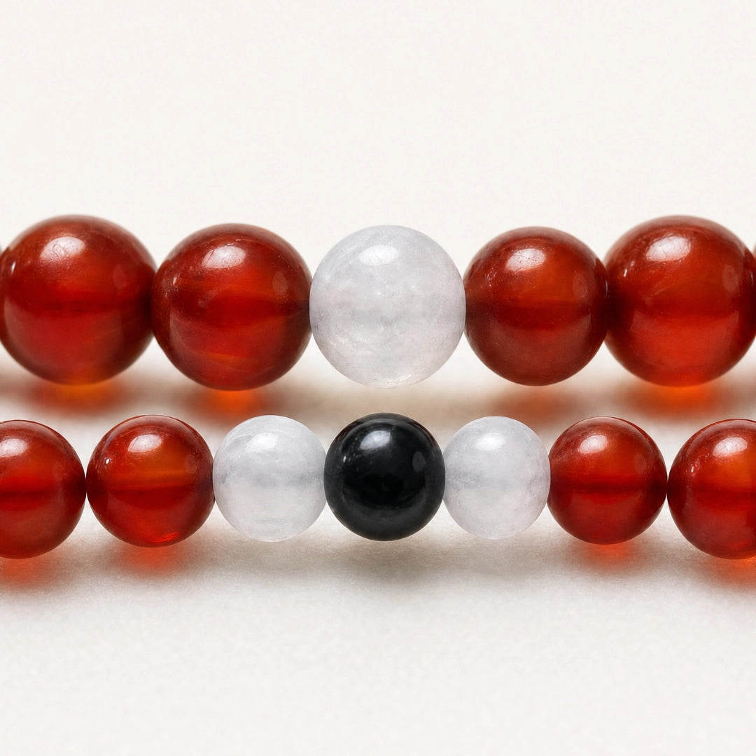 Detalle macro de pulseras de pareja en cornalina, jade blanco y turmalina negra