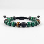 Pulsera masculina elaborada principalmente en piedra natural malaquita verde con acentos de ojo de tigre y piedra volcánica negra.