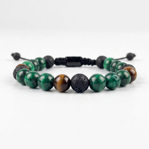 Pulsera masculina elaborada principalmente en piedra natural malaquita verde con acentos de ojo de tigre y piedra volcánica negra.