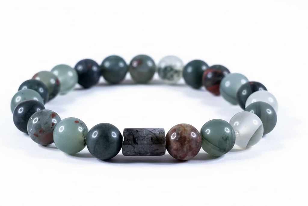 Pulsera de cuentas redondas de piedra Bloodstone natural (verde oscuro con manchas rojas) sobre fondo neutro.
