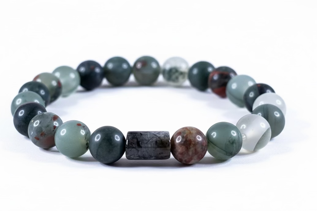 Pulsera de cuentas redondas de piedra Bloodstone natural (verde oscuro con manchas rojas) sobre fondo neutro.