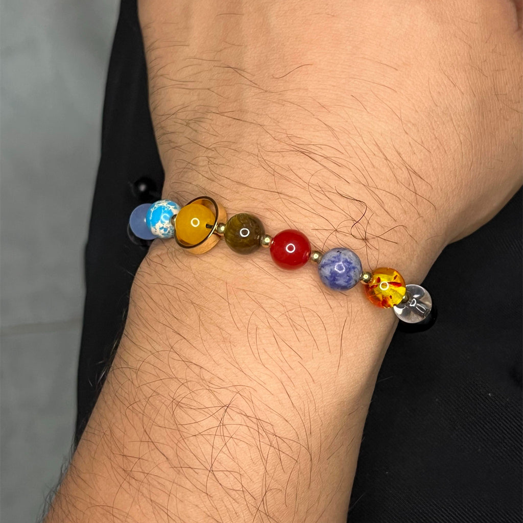 Esta pulsera única reúne las piedras naturales que representan a los 9 planetas del sistema solar, combinadas con cuentas de Ónix negro, símbolo de fuerza y protección