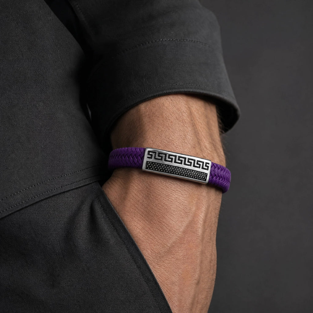 Pulsera de cuero morada en fondo gris minimalista con placa metalica 